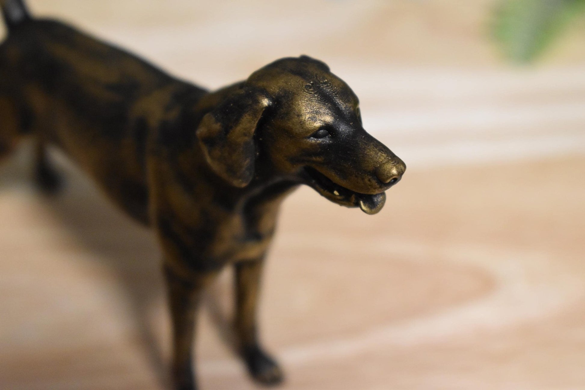Close-up of a black and gold American Foxhound standing statue, highlighting intricate details of the sculpture