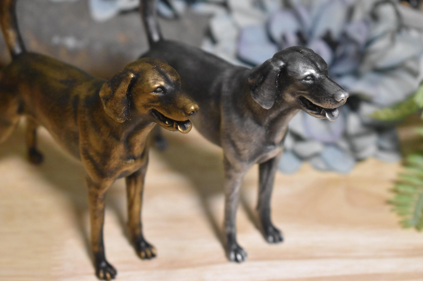 lack and gold, and black and silver American Foxhound standing statues side by side, showcasing both color variations in one image