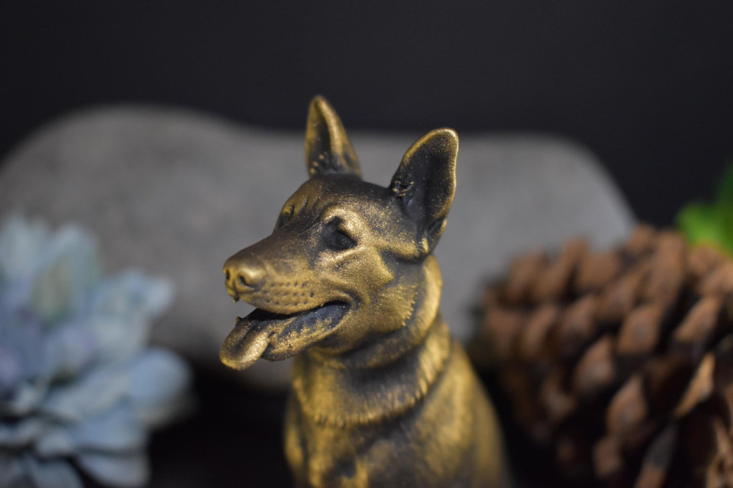 Close-up left side of a black and gold German Shepherd sitting statue, highlighting fine craftsmanship.