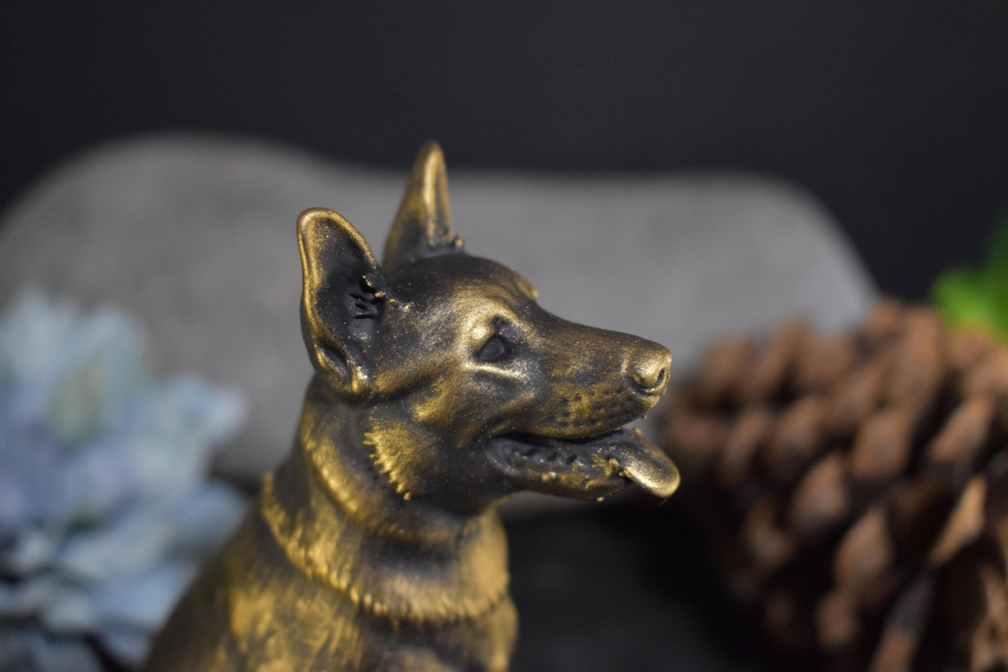 Close-up right side of a black and gold German Shepherd sitting statue, showcasing intricate facial details.