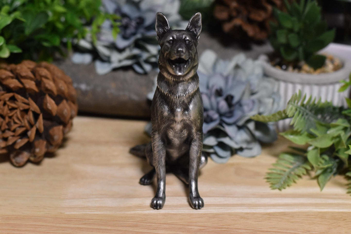 Front view of a black and silver German Shepherd sitting statue, displaying the breed’s iconic expression.